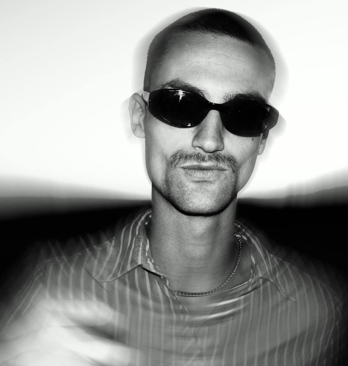 Oneiroi in black and white, wearing sunglasses and a striped shirt